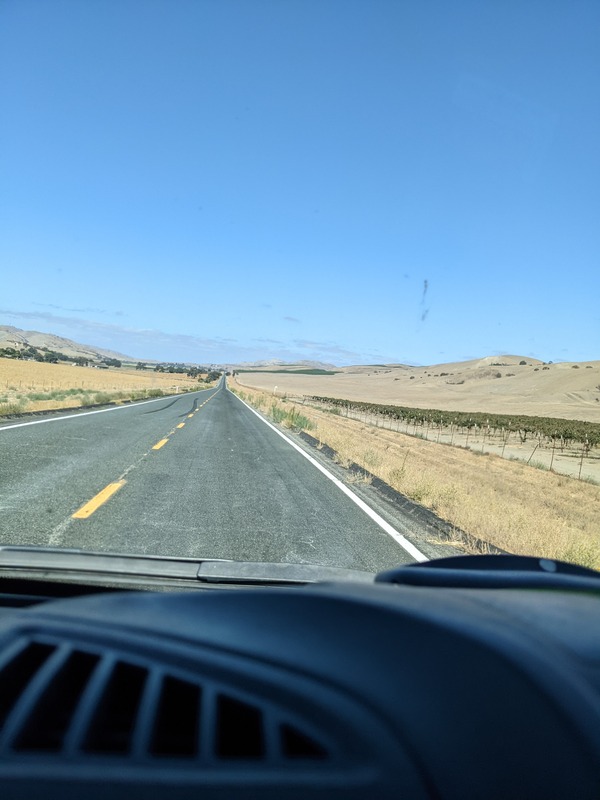 Photo through the van windshield of the open road stretching into the distance