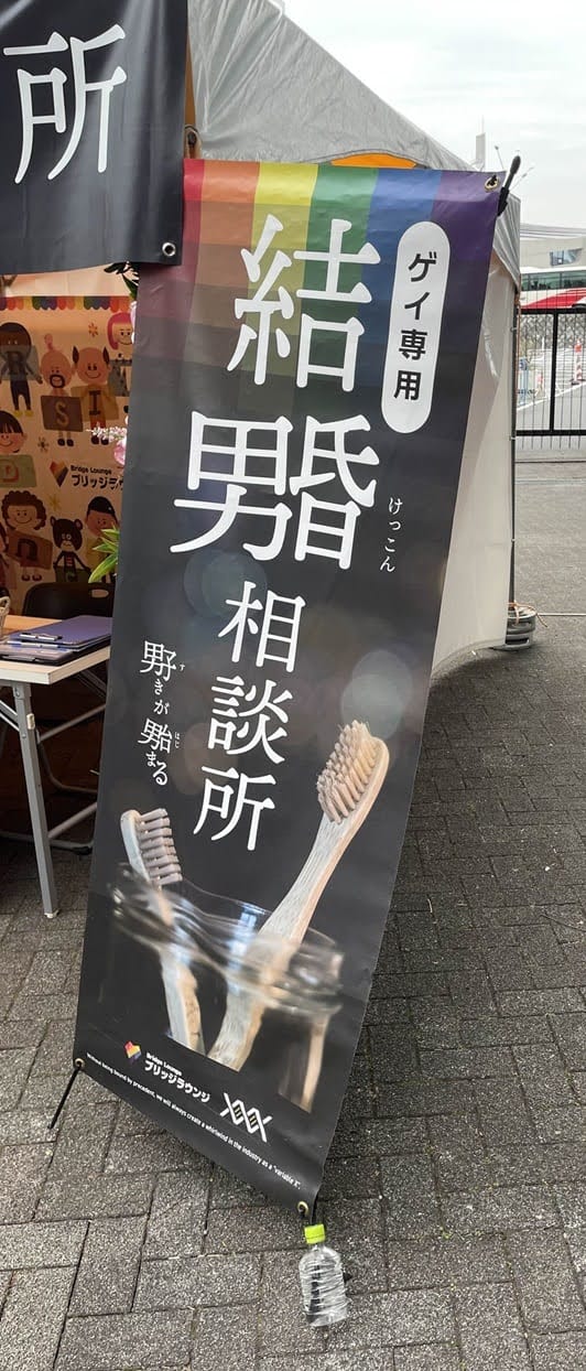 Banner with a rainbow and black background, and two toothbrushes in a jar, with wordplay as described in the text