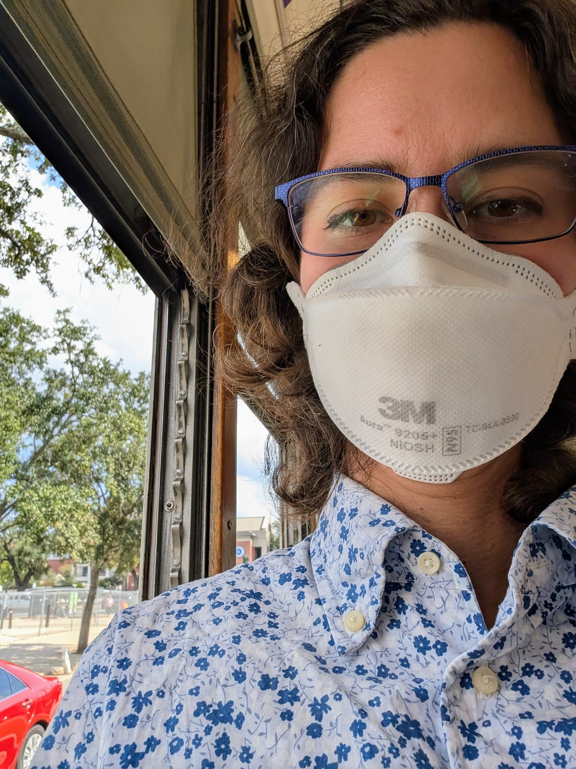 A selfie of Rey wearing a mask on a cable car